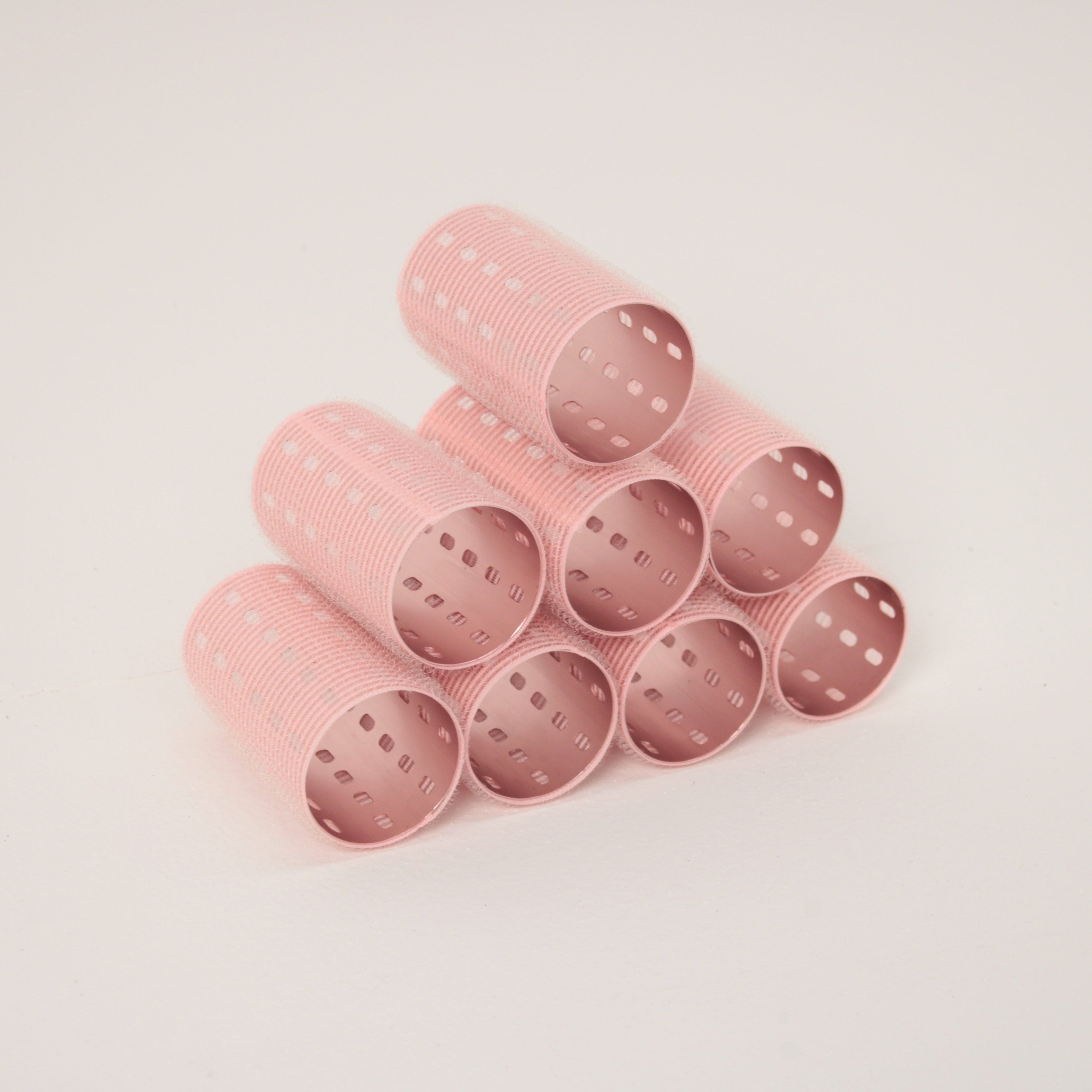 Stack of 8 pink velcro aluminium hair rollers on a light gray background